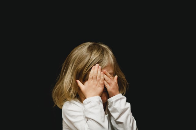 Child covering her eyes